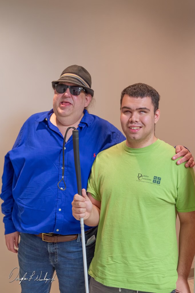 Joey Stuckey standing side-by-side with Armando Vias, with his arm around Armando's shoulder.